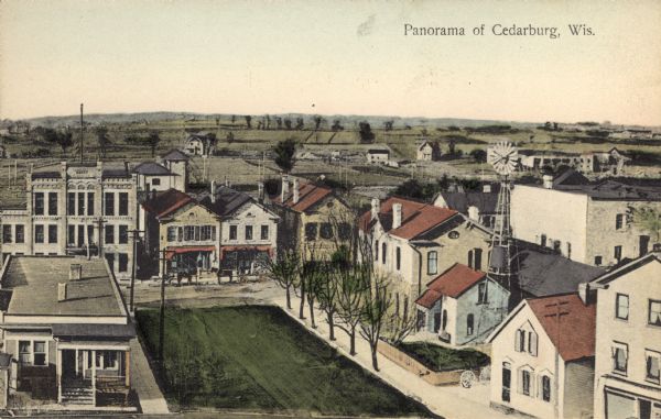 Hand-colored panoramic view of Cedarburg. Dwellings and green space in the foreground. A commercial street running through the center. A windmill is on the right. Caption reads: "Panorama of Cedarburg, Wis."