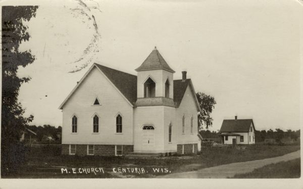 Exterior view from road towards the M.E. Church, a white wooden building with a bell tower. Caption reads: "M.E. Church, Centuria, Wis."