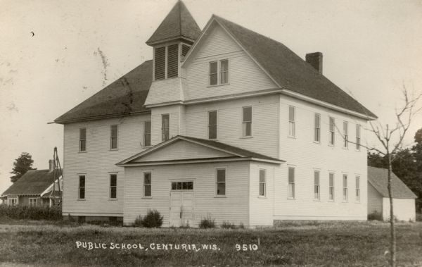Exterior view of the public school, which is a two-story wooden building with a bell tower. Caption reads: "Public School, Centuria, Wis."
