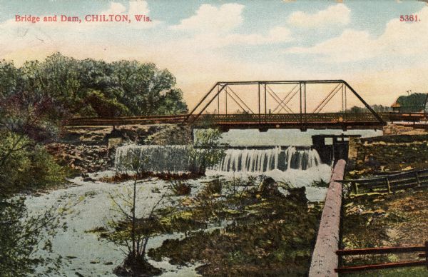 Hand-colored view of the bridge and dam on the river in Chilton. Caption reads: "Bridge and Dam, Chilton, Wis."
