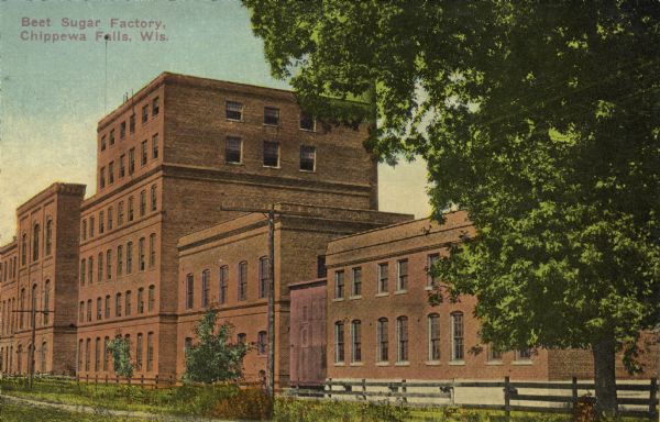 Colorized postcard. Three-quarter view of a beet sugar factory, with five sections of the building at different heights, including one that is five-stories. Caption reads: "Beet Sugar Factory, Chippewa Falls, Wis."