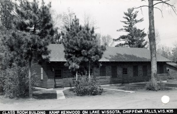 Exterior view of the classroom building at Kamp Kenwood on Lake Wissota. Caption reads: "Class Room Building Kamp Kenwood on Lake Wissota, Chippewa Falls, Wisconsin."
