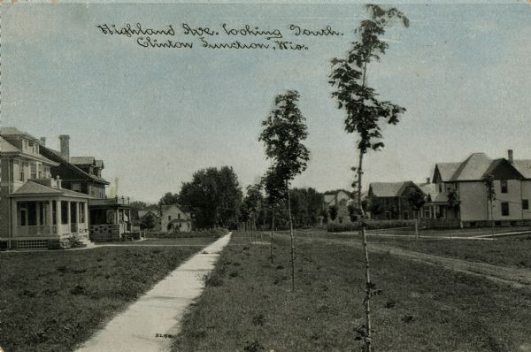 Colorized postcard view of Highland Avenue looking south, with homes, sidewalks and a row of young trees on the terrace. Caption reads: "Highland Ave., looking South, Clinton Junction, Wis."