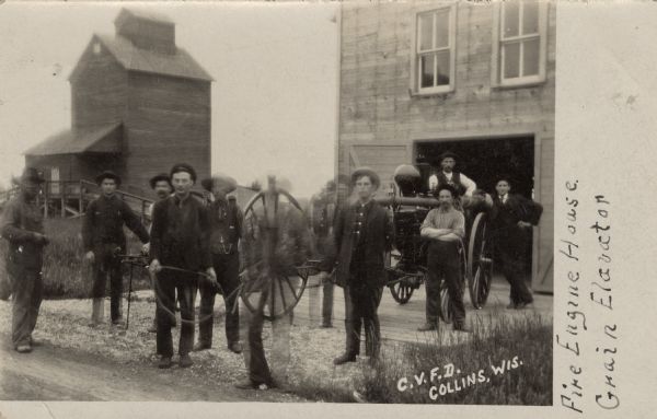 Photographic postcard of the Collins fire department volunteers, a fire wagon, the fire house and a nearby grain elevator. Caption reads: "C.V.F.D., Collins, Wis."