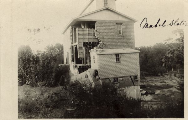 Photographic postcard of a damaged mill. The following is part of the written message on the card: "Will send you a picture of the mill so you may see a part of the damage that was done." Dated September 23, 1910.