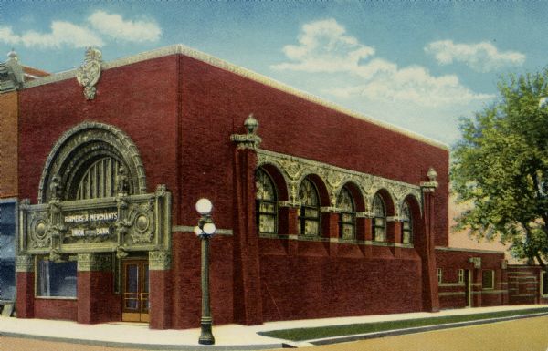 Color postcard of the Farmers' and Merchants' Union Bank. The building was designed by Louis H. Sullivan and constructed in 1919 of Crawfordsville brick and glazed terra cotta.