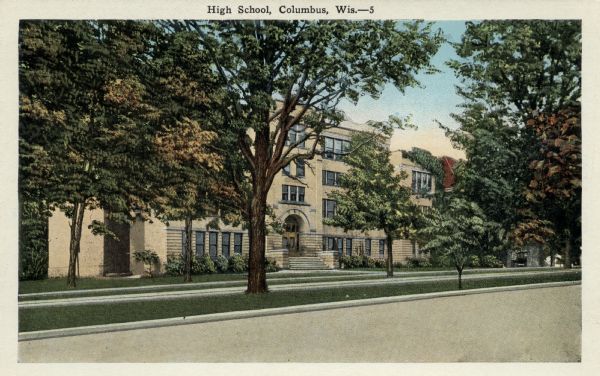 Color postcard view across street toward the high school. Caption reads: "High School, Columbus, Wis."