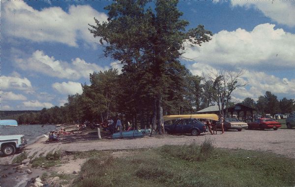 Chrome color postcard of the boat launch area. Text on back reads: "Forest County Veteran's Memorial Park located 3 miles from Crandon, WI on the south shore of Lake Metonga. Excellent camping, swimming, and fishing. Picnic area and boat landing." 