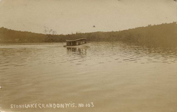 Photographic postcard across water, showing launch owned by Schlitz Brewery of Milwaukee operating on Stone Lake. Caption reads: "Stone Lake, Crandon, Wis."