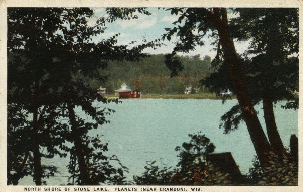 Colorized postcard view. Caption reads: "North Shore of Stone Lake. Planets (Near Crandon) Wis." Caption on back reads: "Looking towards the picturesque recreation resort, 'The Planets.' 'Neptune' cottage at water's edge."