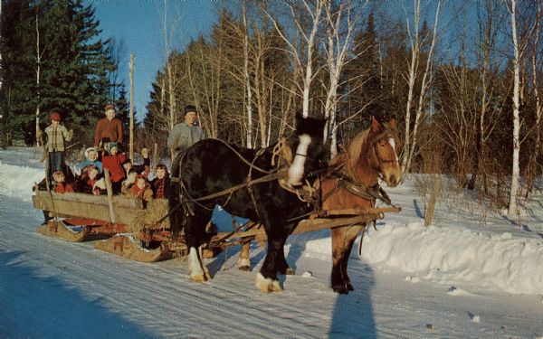 Group of people on horse-drawn sleigh. Caption on back reads: "Greetings from Crandon, Wisconsin. Sleigh Ride. Remember these days? Fill the sled with straw, hand bells on the horses, and we're off on a bristling, fun-filled ride through the snowy woods."