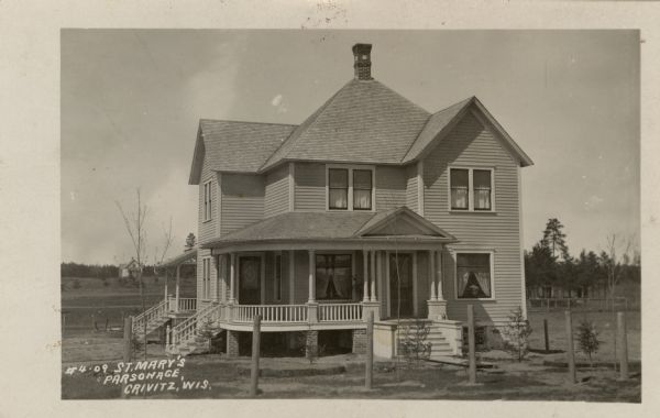 Photographic postcard view of St. Mary's parsonage, with a front and side porch. Caption reads: "St. Mary's Parsonage, Crivitz, Wis."