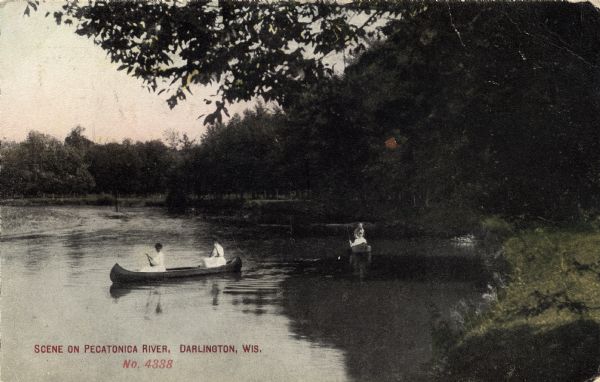 View of two women canoeing on the Pecatonica River. There are two more people in a boat in the background on the right. Caption reads: "Scene on Pecatonica River, Darlington, Wis."