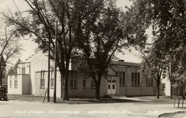 Photographic postcard view from street intersection of the High School gymnasium. Caption reads: "High School Gymnasium, Darlington, Wis."