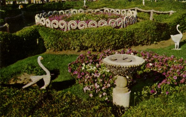 View looking down at a sundial and stone geese in a garden area with a seashell flower ring at the Dickeyville Grotto.