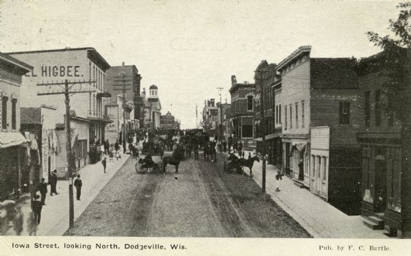 Elevated view of busy Iowa Street scene, looking north, with the Hotel Higbee on the left, and the Iowa County Courthouse in the background. Caption reads: "Iowa Street, looking North, Dodgeville, Wis."