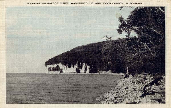 View along shoreline towards Washington Harbor Bluff. There are two men standing at the shoreline on the right.