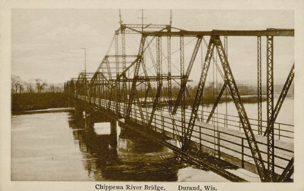 Photographic postcard view from shoreline of the truss bridge over the Chippewa River. Caption reads: "Chippewa River Bridge, Durand, Wis."