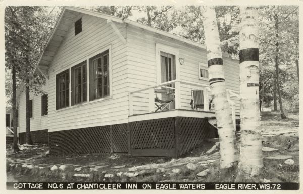Close-up of the cottage and birch trees at the resort located east of Eagle River at 1458 E. Dollar Lake Road at the outlet of Eagle Lake. Caption reads: "Cottage No. 6 at Chanticleer Inn on Eagle Waters, Eagle River, Wis."