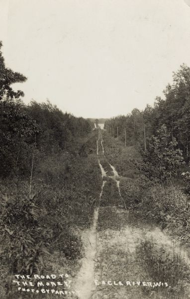 The two-track unpaved road to "The Morey" northeast of Eagle River, on the east side of Otter Lake. Caption reads: "The Road to 'The Morey.'"