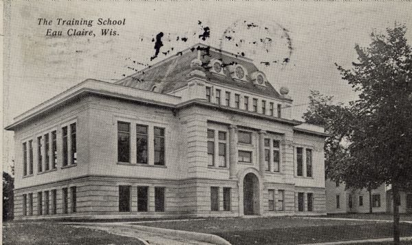 View of a stone building with an arched entrance. Caption reads: "The Training School, Eau Claire, Wis."