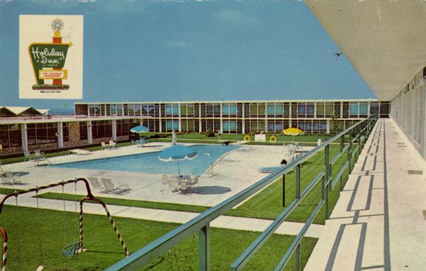 A color photographic view from a balcony of the enclosed courtyard at the Holiday Inn on Clairemont Avenue, showing the pool and a swing set. 