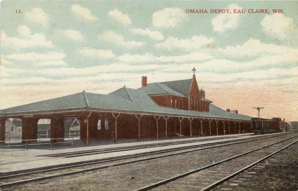 Color enhanced photographic postcard view of the Omaha railroad station. Caption reads: "Omaha Depot, Eau Claire, Wis."