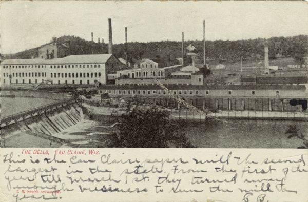 Black and white elevated view of the Dells Pulp and Paper Mill on the Eau Claire River. Caption reads: "The Dells, Eau Claire, Wis."