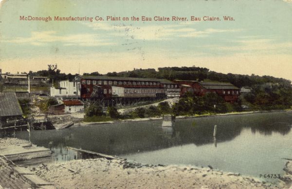 Colorized view across water toward the McDonough Manufacturing Company Plant. Caption reads: "McDonough Manufacturing Co. Plant on the Eau Claire River, Eau Claire, Wis."