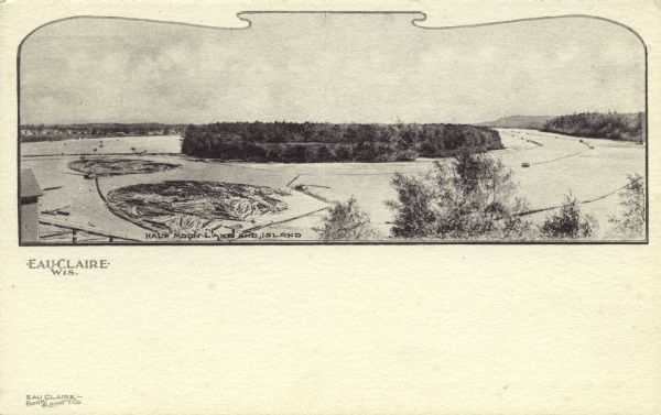 Black and white elevated view of Half Moon Lake and Island. Logs are in a boom in the lake. Caption reads: "Half Moon Lake and Island," and "Eau Claire, Wis."