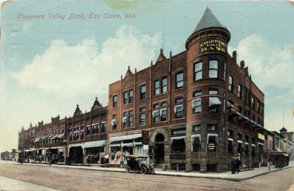 Colorized postcard view across street towards the Chippewa Valley Bank on a street corner. A Model T is parked along the curb in front. Caption reads: "Chippewa Valley Bank, Eau Claire, Wis."