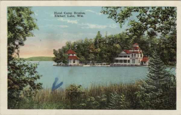 Colorized view of a lakeside hotel with a pier and boathouse. Caption reads: "Hotel Camp Brosius, Elkhart Lake, Wis."