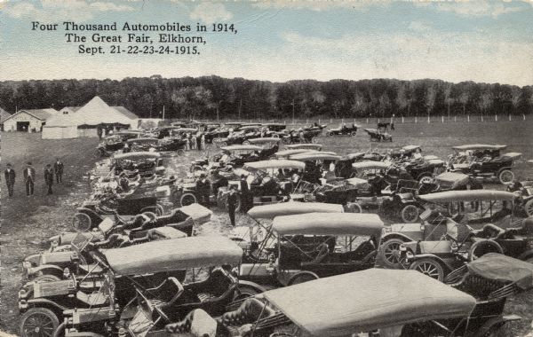 Elevated view of a small sample of "4000 cars" parked at the Great Fair. Caption reads: "Four Thousand Automobiles in 1914, The Great Fair, Elkhorn, Sept. 21-22-23-24-1915."
