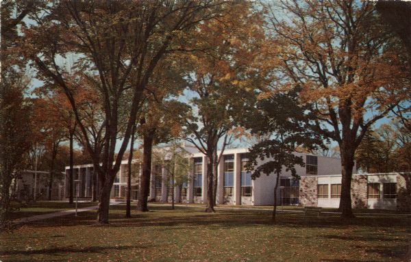 View across lawn and trees in fall color toward the new county court house.