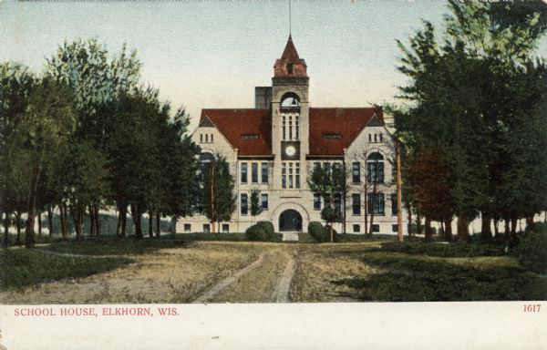Colorized view of the school from an unpaved road. The building has a bell tower in the center above an arched entrance. Caption reads: "School House, Elkhorn, Wis."