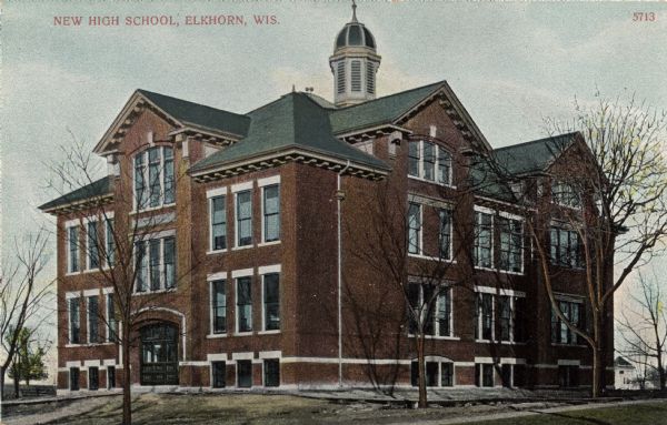 Colorized view of the high school, a two-story brick building with large windows and a bell tower in the center of the roof. Caption reads: "New High School, Elkhorn, Wis."