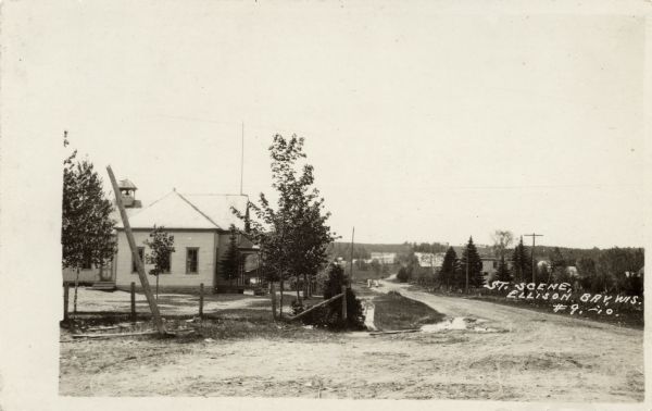 Street scene in Ellison Bay. On the far left is a building with a bell tower on the roof. Caption reads: "St. Scene, Ellison Bay, Wis."