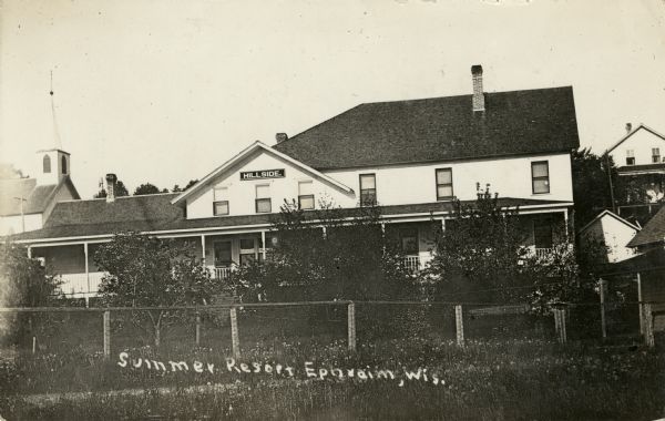 The Hillside Resort in Ephraim. There is a church in the background on the left. Caption reads: "Summer Resort, Ephraim, Wis."