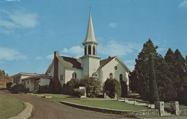 Color postcard of the Moravian Church, established 1853. It is a large, white wooden building with a steeple over the entrance.