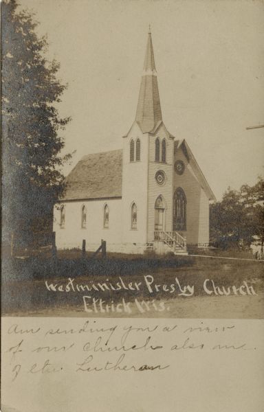 Sepia-toned view of the Presbyterian Church, which is a wooden structure with a large arched window in front and a steeple over the entrance.