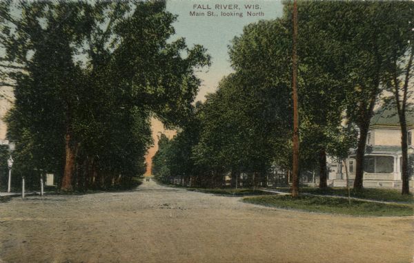 View down a tree-lined street in a residential neighborhood. Caption reads: "Fall River, Wis., Main St., looking North."