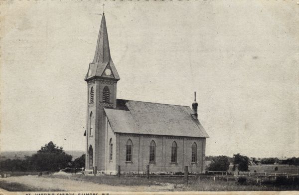 Black and white photographic postcard view of a rural church with a clock on the steeple. Caption reads: "St. Martin's Church, Fillmore, Wis."