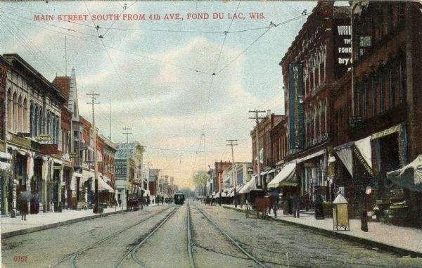 View of Main Street lined with businesses, and street car tracks running down the center. Three dentist offices are on the left. Caption reads: "Main Street South from 4th Ave., Fond du Lac, Wis."