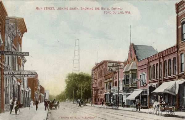 View of Main Street with the E.R Smith Printing Company on the left and the Hotel Erving on the right. Buggies and bicycles are on the street. There is a tower in the background. Caption reads: "Main Street, Looking South, Showing the Hotel Erving, Fond du Lac, Wis."