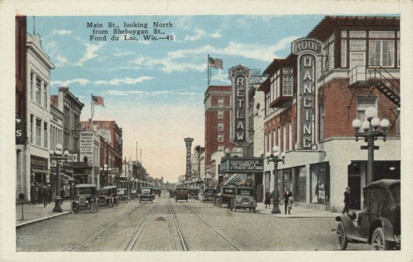 View of Main Street with the Retlaw Theater on the right. Automobiles and street car tracks are in the center of the street. Caption reads: "Main Street, looking North from Sheboygan St., Fond du Lac, Wis."