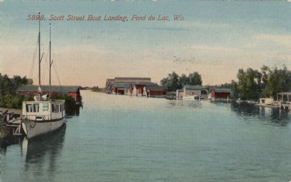 Color illustration of several small boathouses along an outlet of Lake Winnebago. A sailboat is moored in the foreground. Caption reads: "Scott Street Boat Landing, Fond du Lac, Wis."