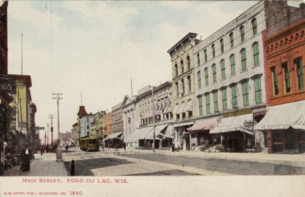 Hand-colored view of Main Street with a streetcar and multi-colored facades. Caption reads: "Main Street, Fond du Lac, Wis."