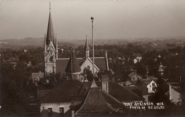 Elevated view of Fort Atkinson, with a church in the foreground surrounded by rooftops. Caption reads: "Fort Atkinson, Wis."