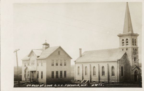View of the St. Rosa church and school located at the eastern side of the village on the south side of the road. Caption reads: "St. Rosa of Lima, C. & S. Fredonia, Wis."