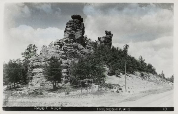 Hand-colored postcard of Rabbit Rock — a rocky outcropping with two towers of stone.
